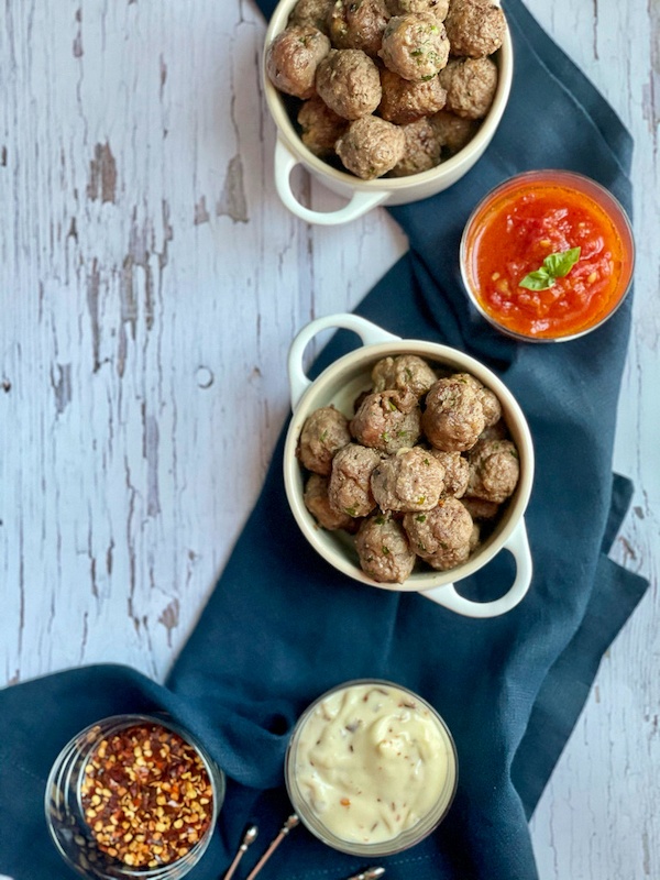 ultimate Meatballs in small bowl with dipping marinara sauce and mayo