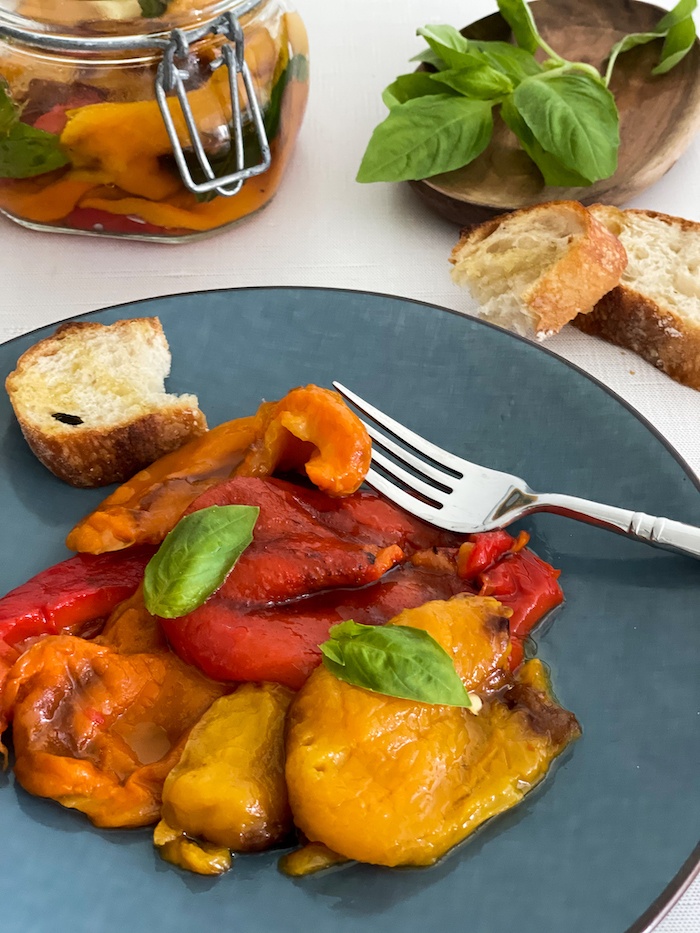 roasted bell peppers on a blue [late with a piece of bread