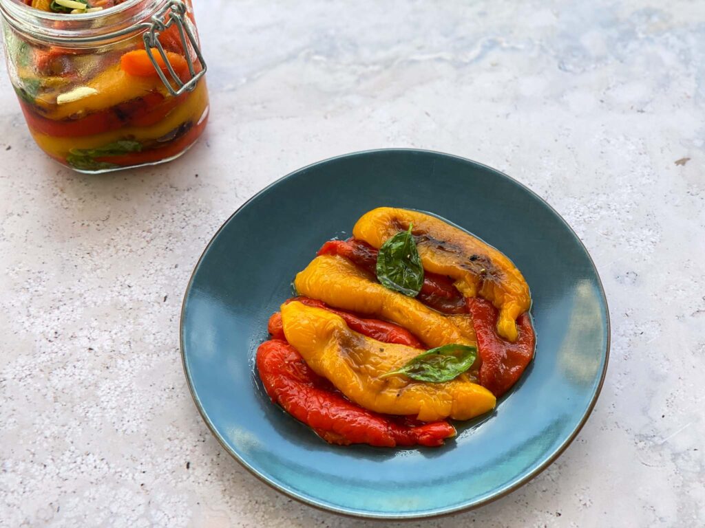 Peppers on a plate with glass jar on the side