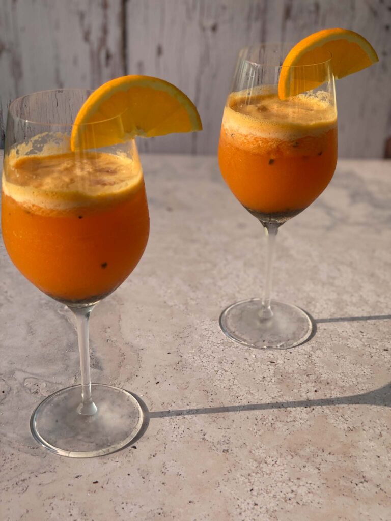 Passion Fruit Spritz in glasses with orange garnish