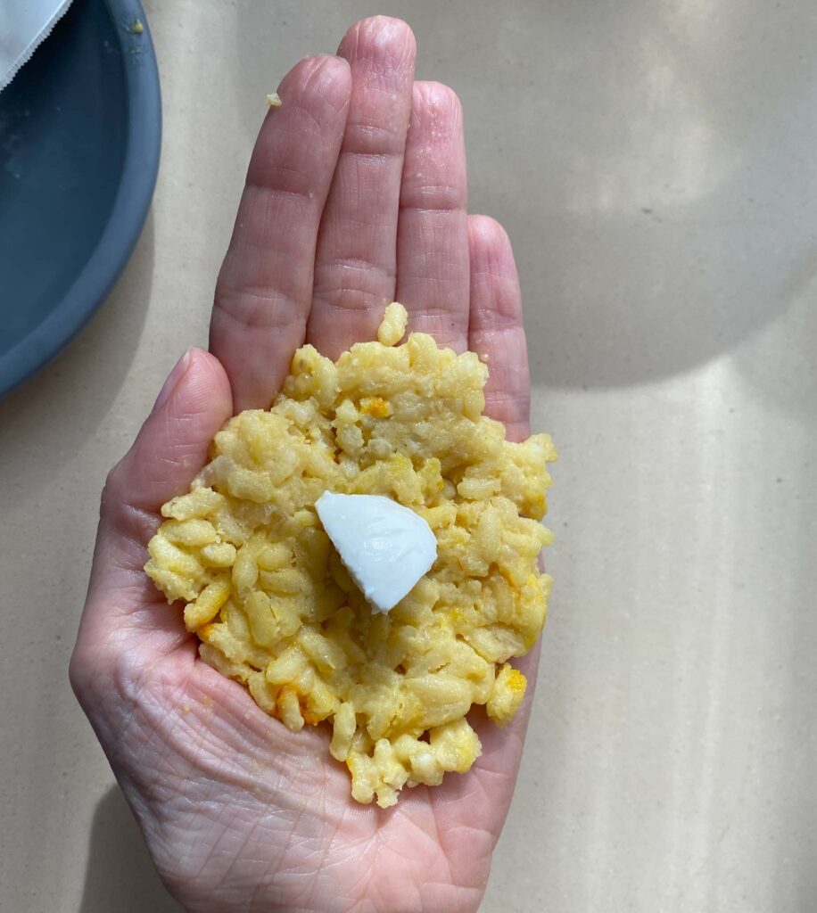 Sicilian Arancini Rice Balls adding mozzarella cube