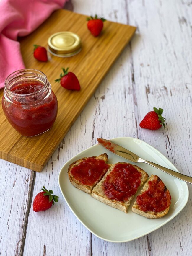 Jar of Jam and a plate with a toast covered by jam.