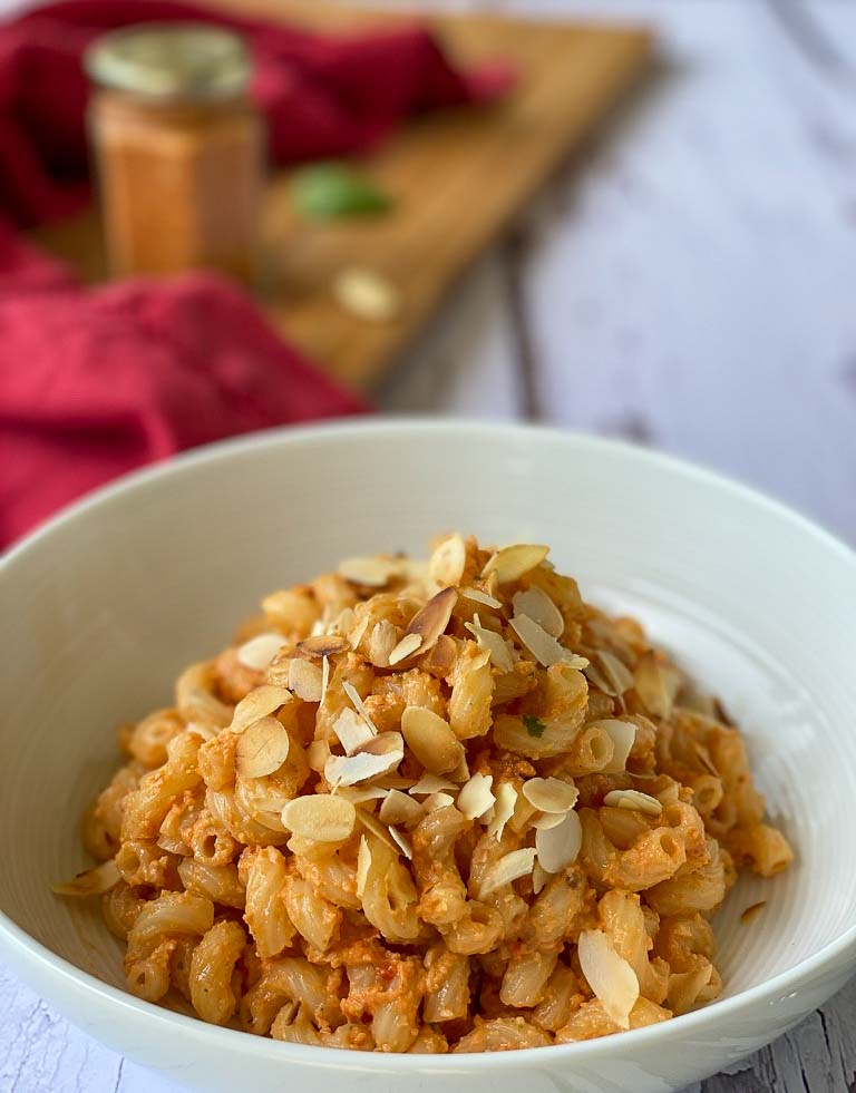 Red Pepper Pesto Macaroni in a plate with jar in background
