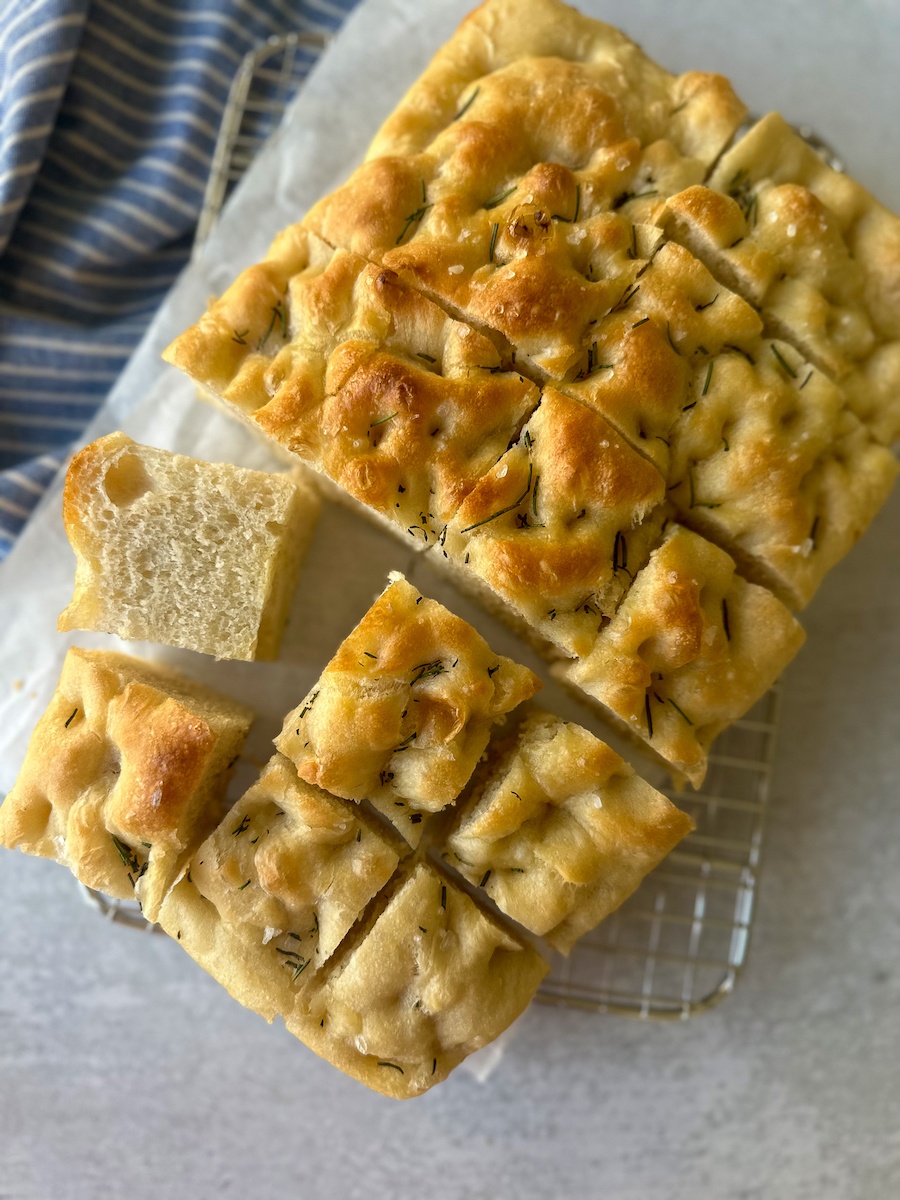 Rosemary focaccia bread on baking tray with details of textures