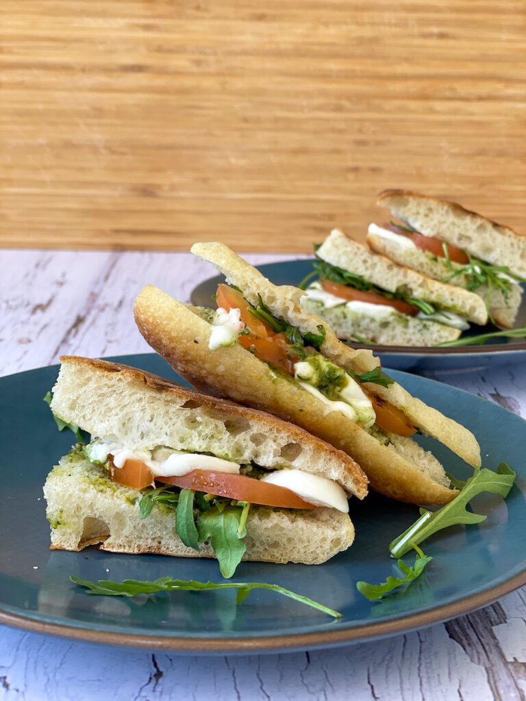 Panini with Pesto, Mozzarella and Tomato on blue plates