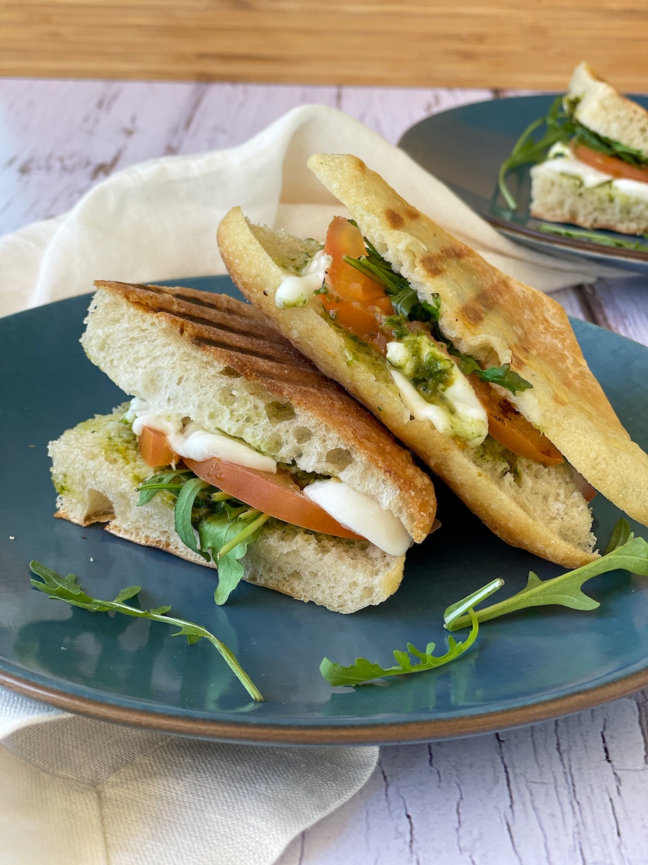 Pesto Panini on a blue plate with a white napkin