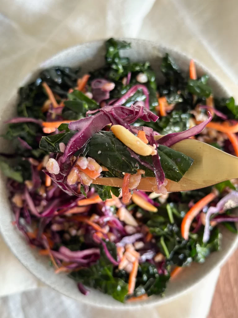 Bite on golden fork of Winter Kale Salad with Farro, Pecorino & Dates