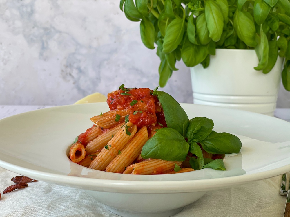 penne pasta in spicy tomato sauce on a white plate