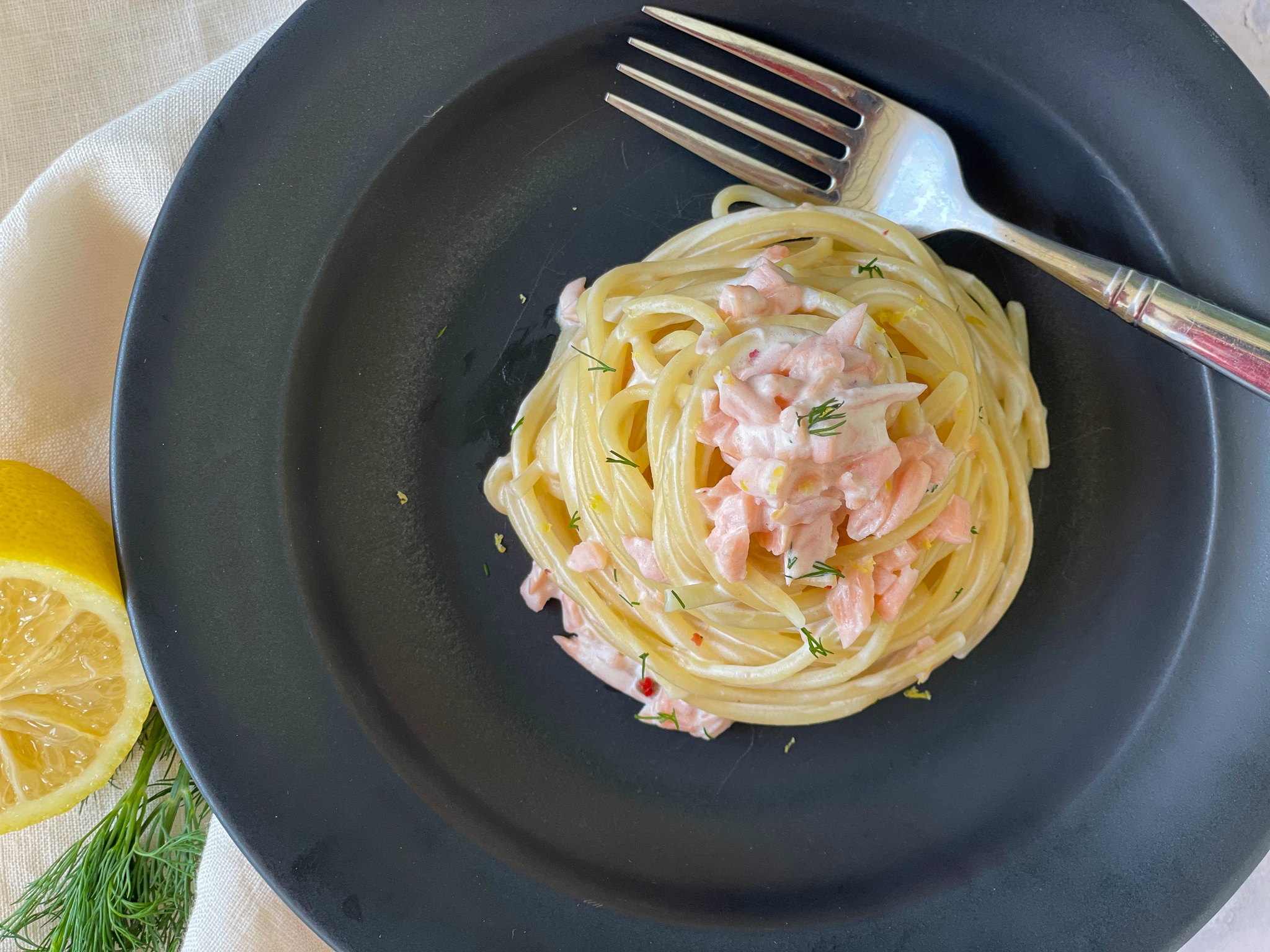 Smoked Salmon Pasta with Mascarpone on a black plate.