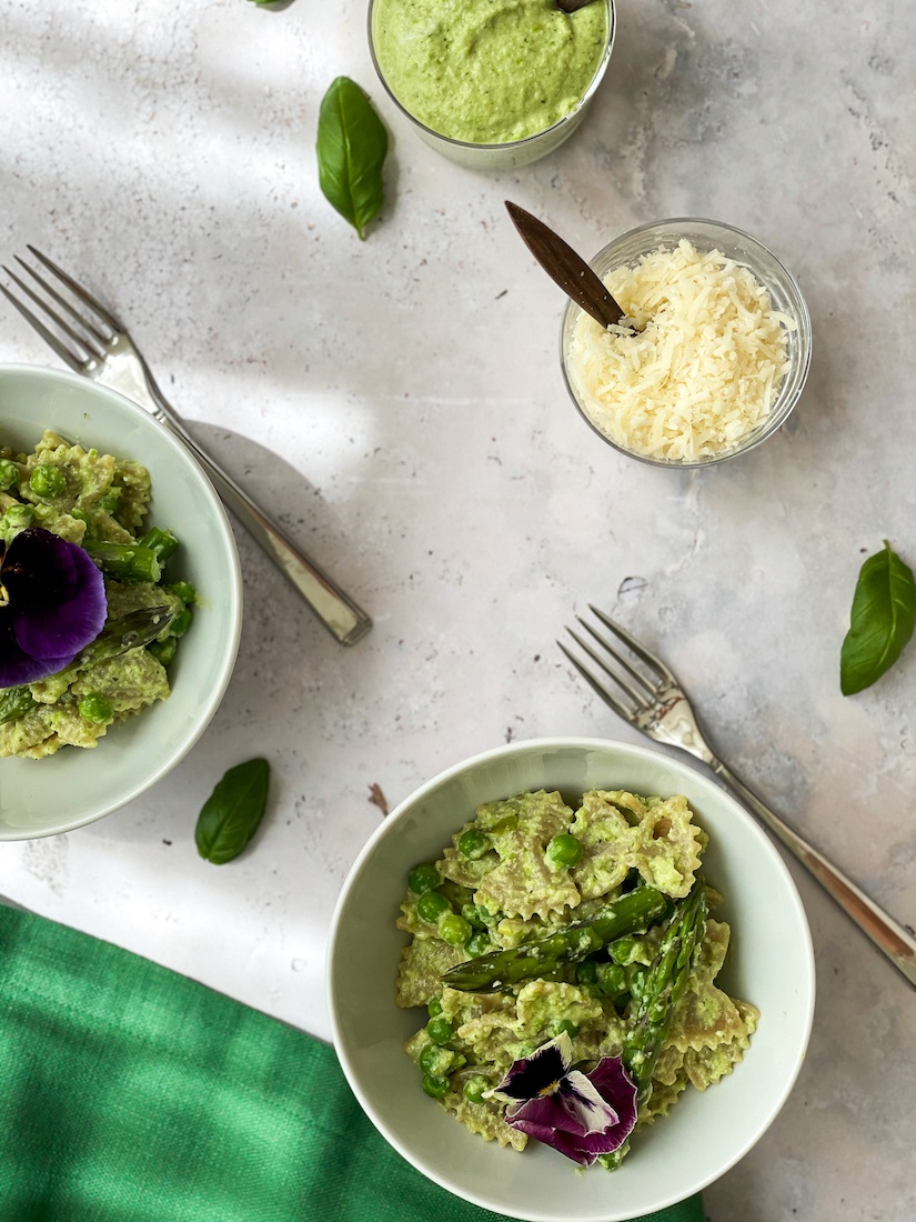 Bowls of pea pesto pasta with Parmesan and more pea pesto