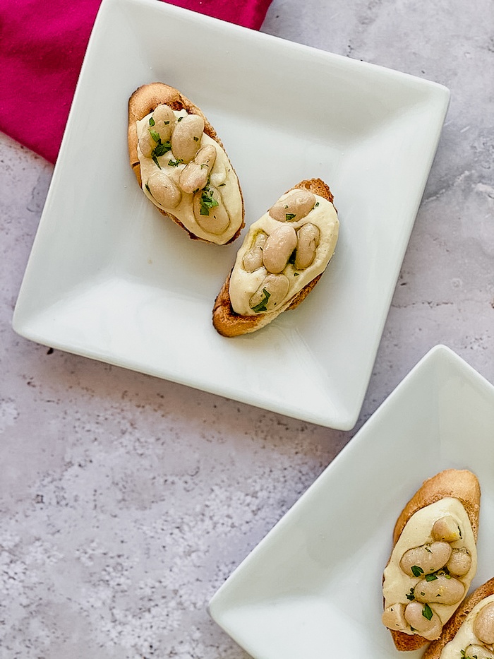 Italian White bean crostini on white plates