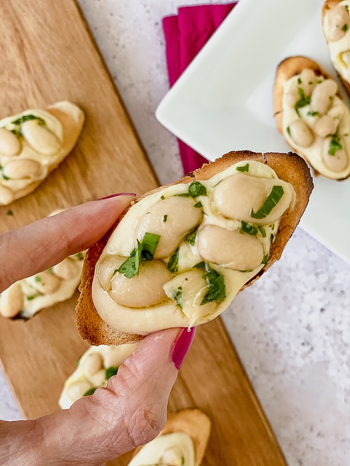 Italian white bean crostini in hands