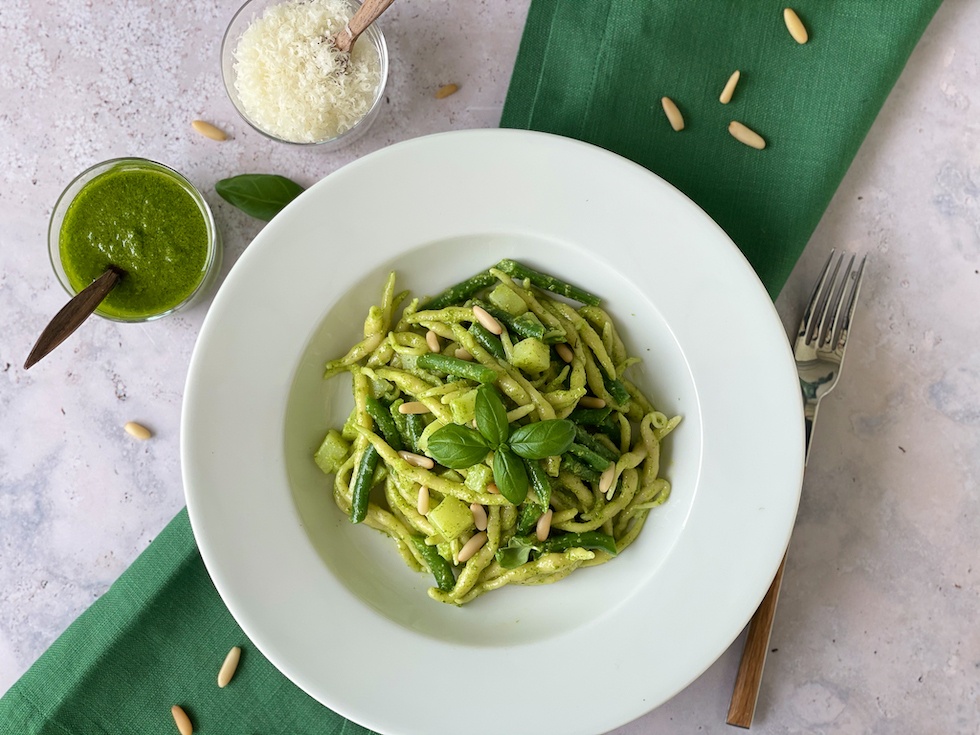 Trofie Pasta with green beans, potatoes and basil pesto on a white plate