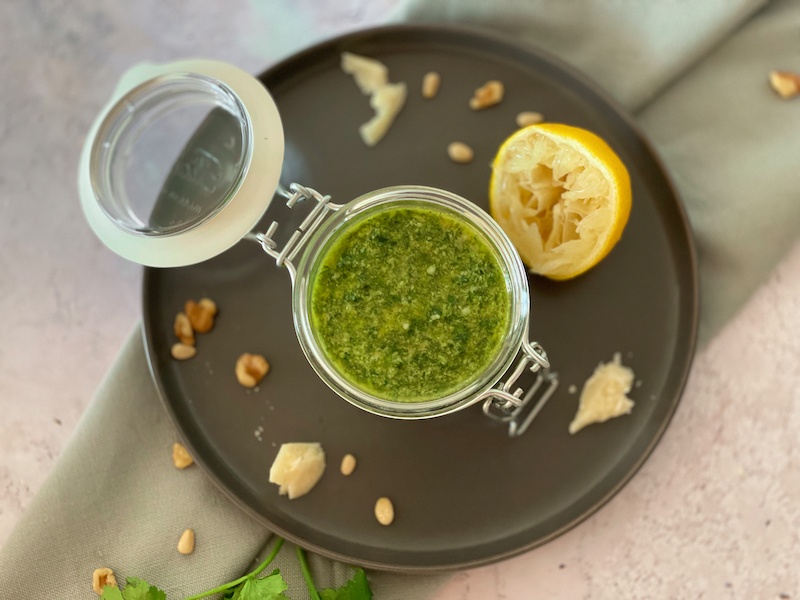 Pesto in a jar on a dark plate