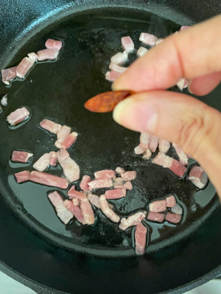 Red pepper flakes in hands to add heat to amatriciana