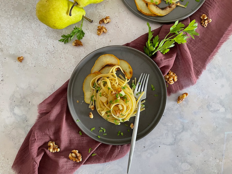 Swirl of spaghetti on a plate with a purple napkin