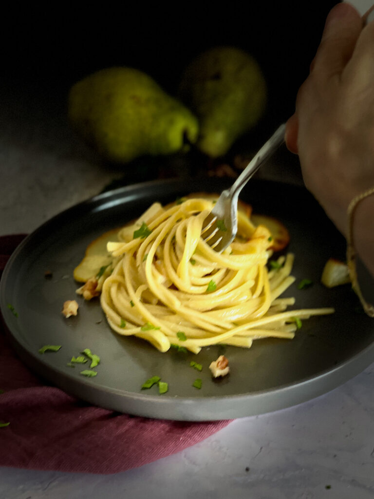 Gorgonzola Pear Spaghetti with a hand making a twirl