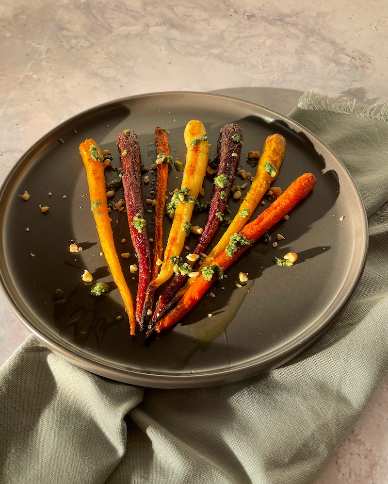 Roasted Carrot on a grey plate topped with pesto