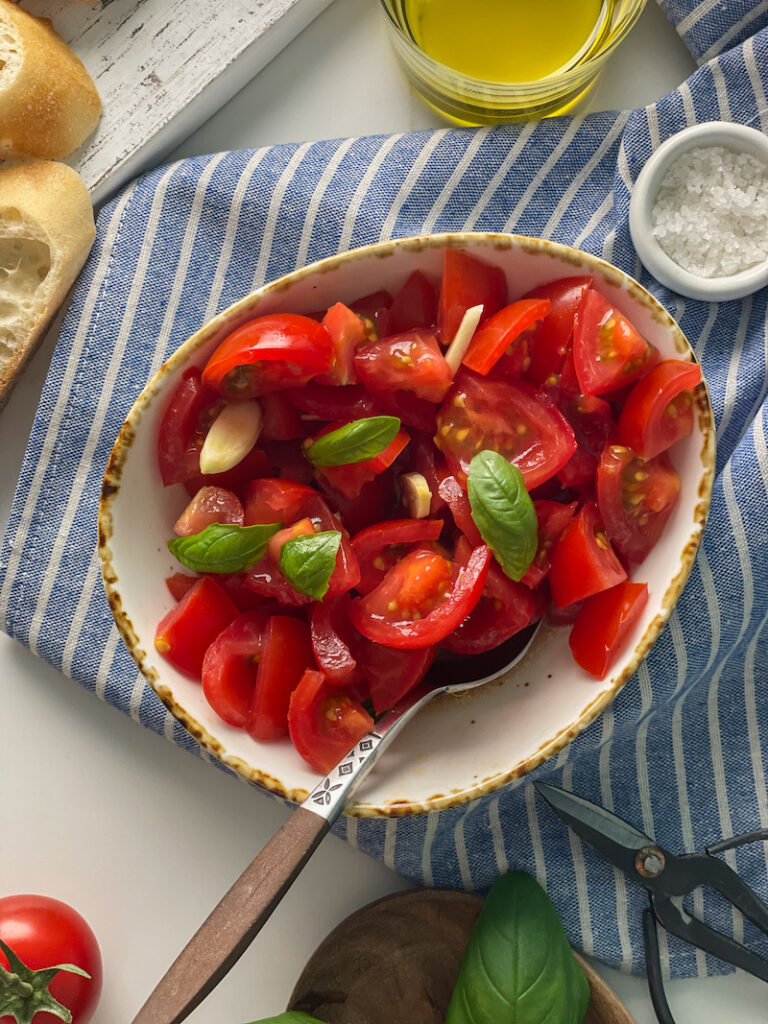 chopped tomatoes for Bruschetta topping in a bowl over a striped towel