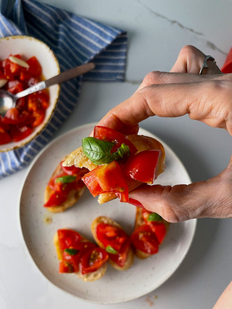 Tomato Bruschetta in hand over a plate