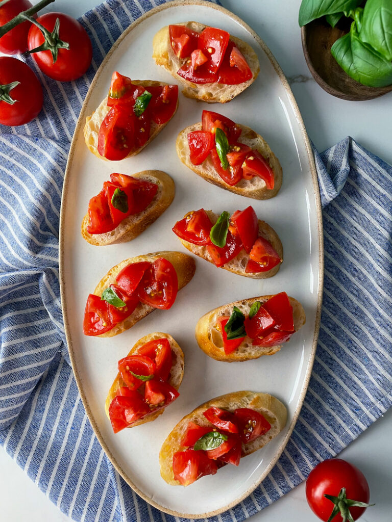 Lot of tomato bruschetta on oval white plate
