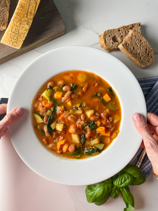 bowl of minestrone soup in hands
