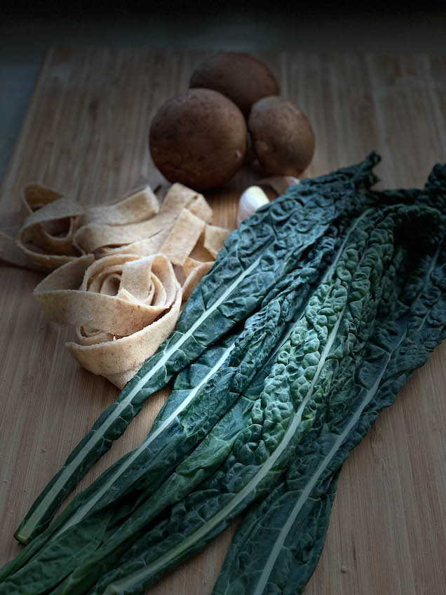 Kale, Mushrooms and tagliatelle on wood board
