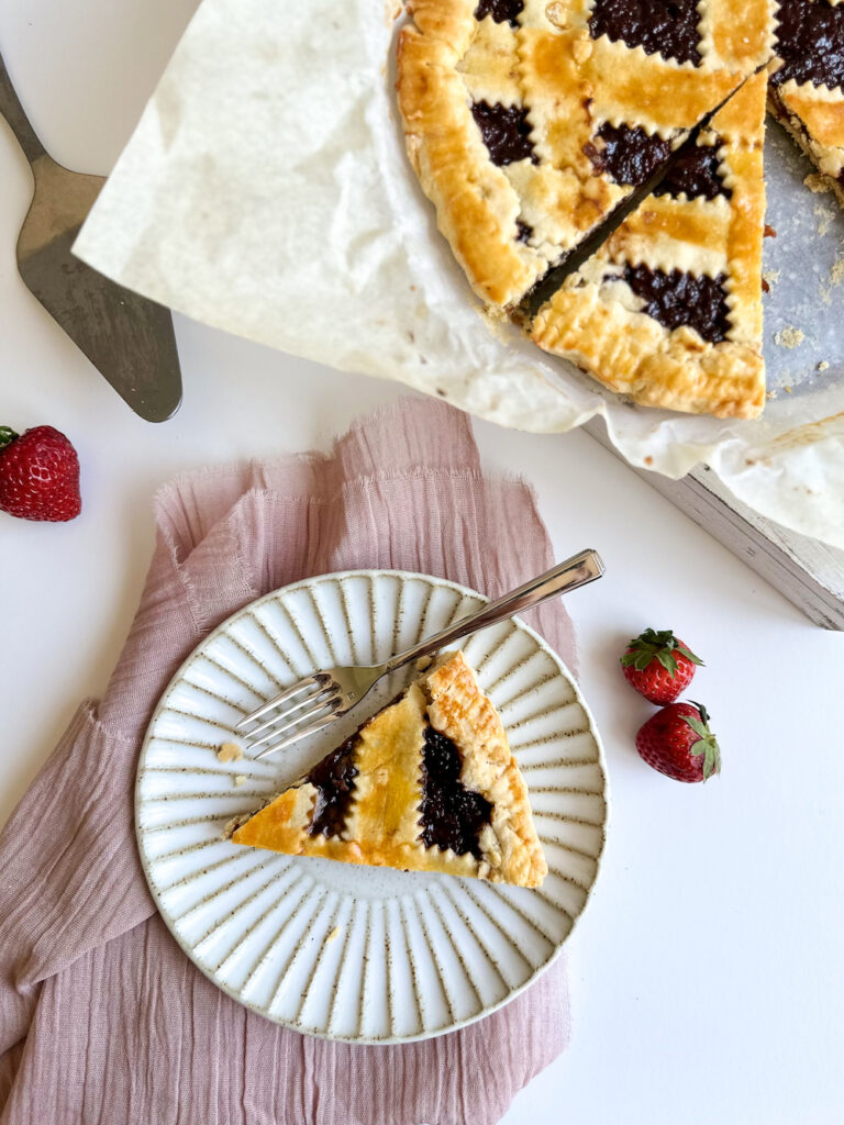 Crostata di marmellata cut and slice on a white plate