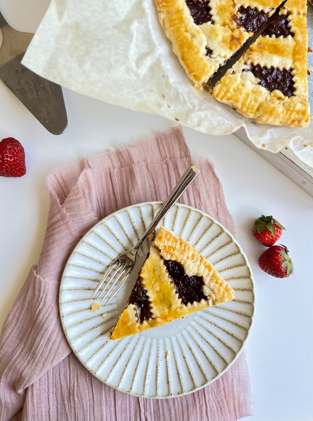 Slice of crostata di marmellata on a white rimmed plate