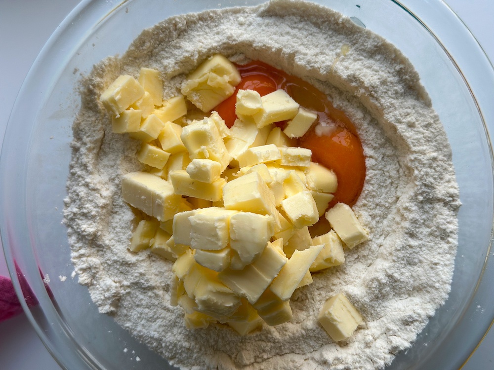 Adding eggs and cubed cold butter in the dry ingredients mixture.