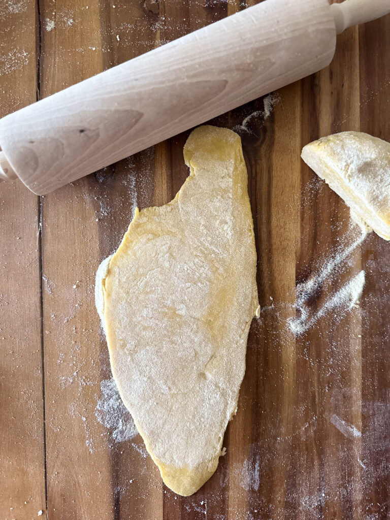 stretching pasta dough with a rolling pin