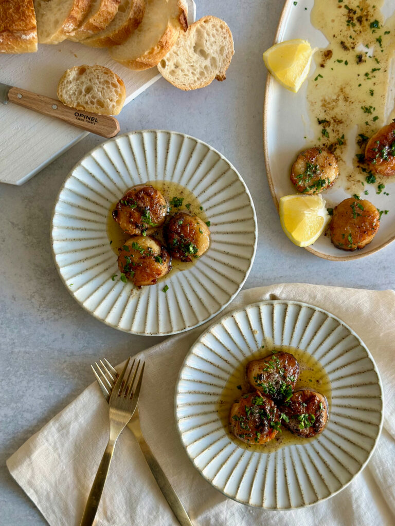 Seared Scallops plated with forks and white towel