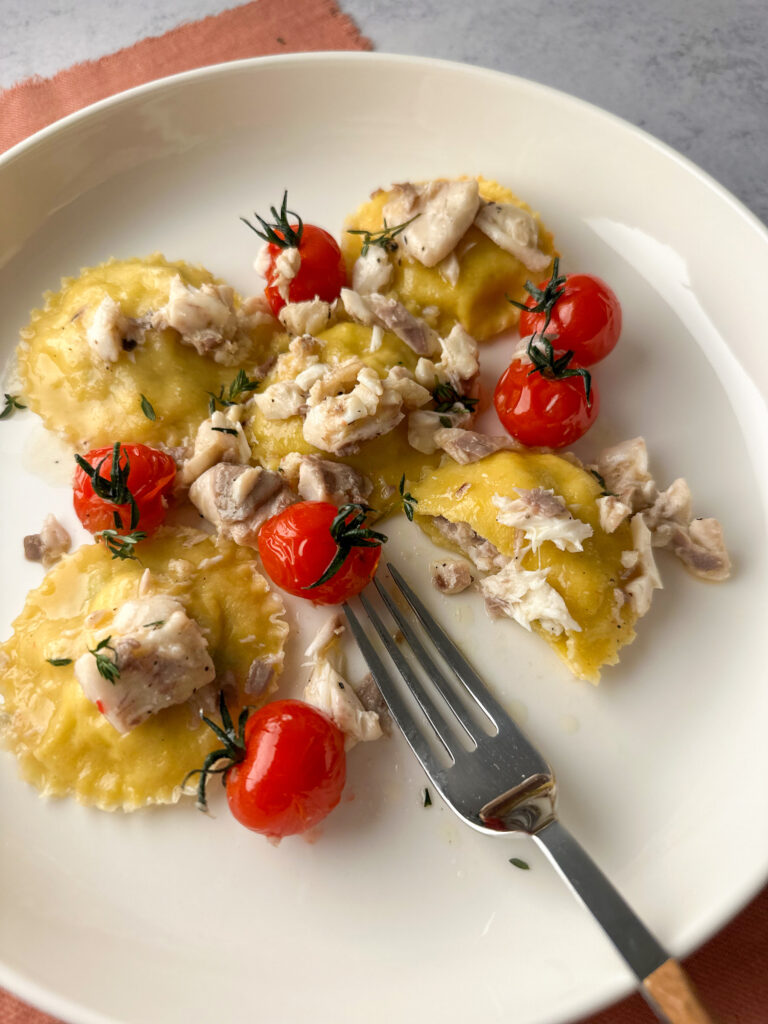 Ravioli filled with sea bass on a plate with a fork