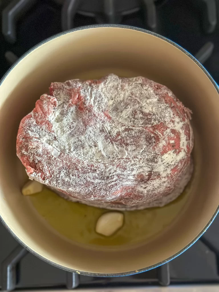 beef chuck in a Dutch pot being roasted on all sides