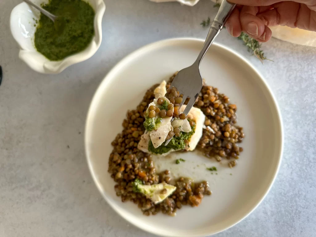 Bite on a fork of Baked Cod in Salsa Verdee