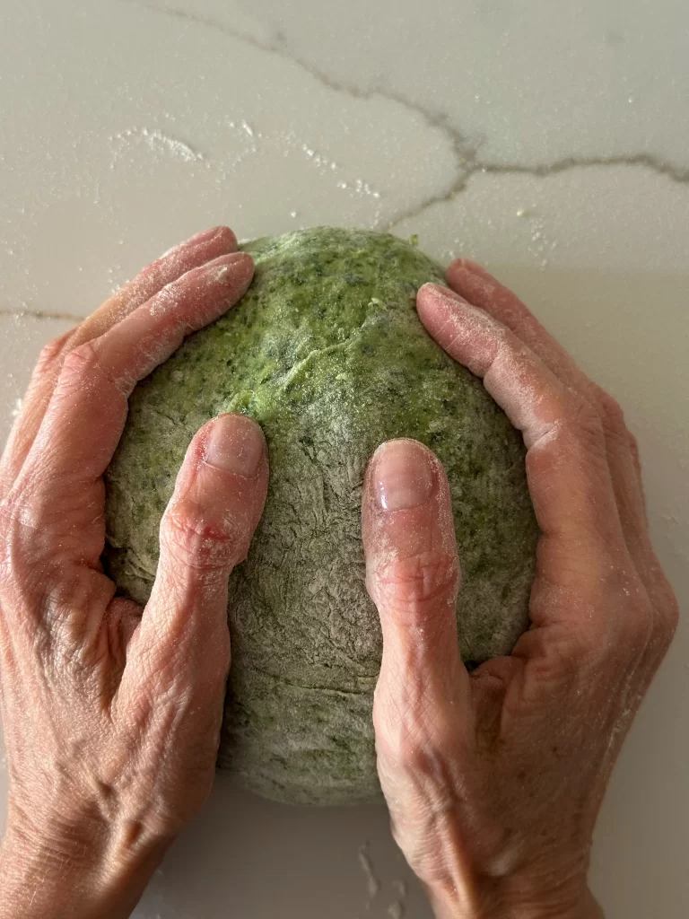 Green fresh egg dough in hands
