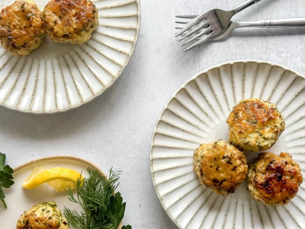 Ground chicken balls on scalloped white plates