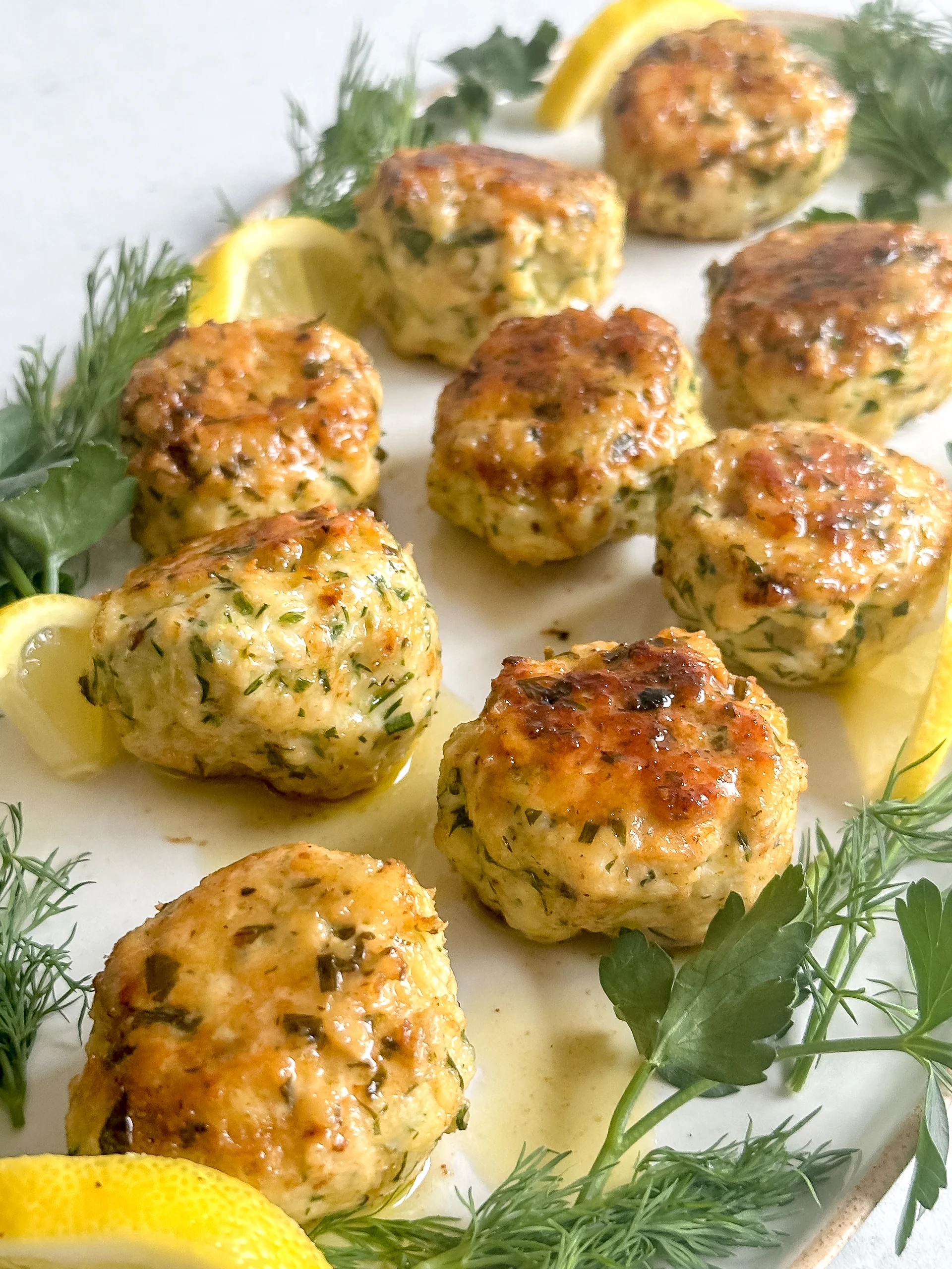 45 degrees view of the chicken meatballs on a white tray.