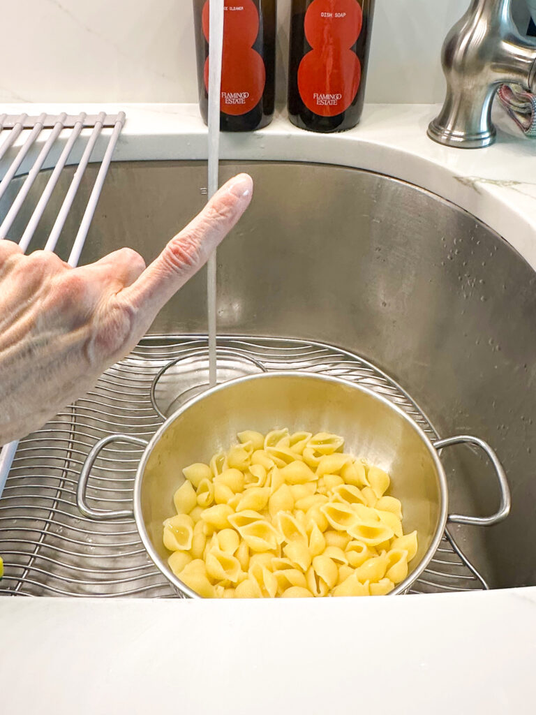 Pasta drained, but with water running outside of colander: NO RINSE