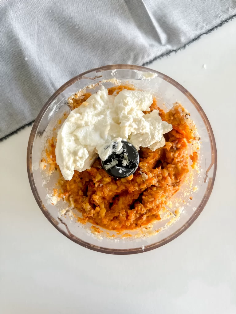 Folding in ricotta into the red pepper pesto.