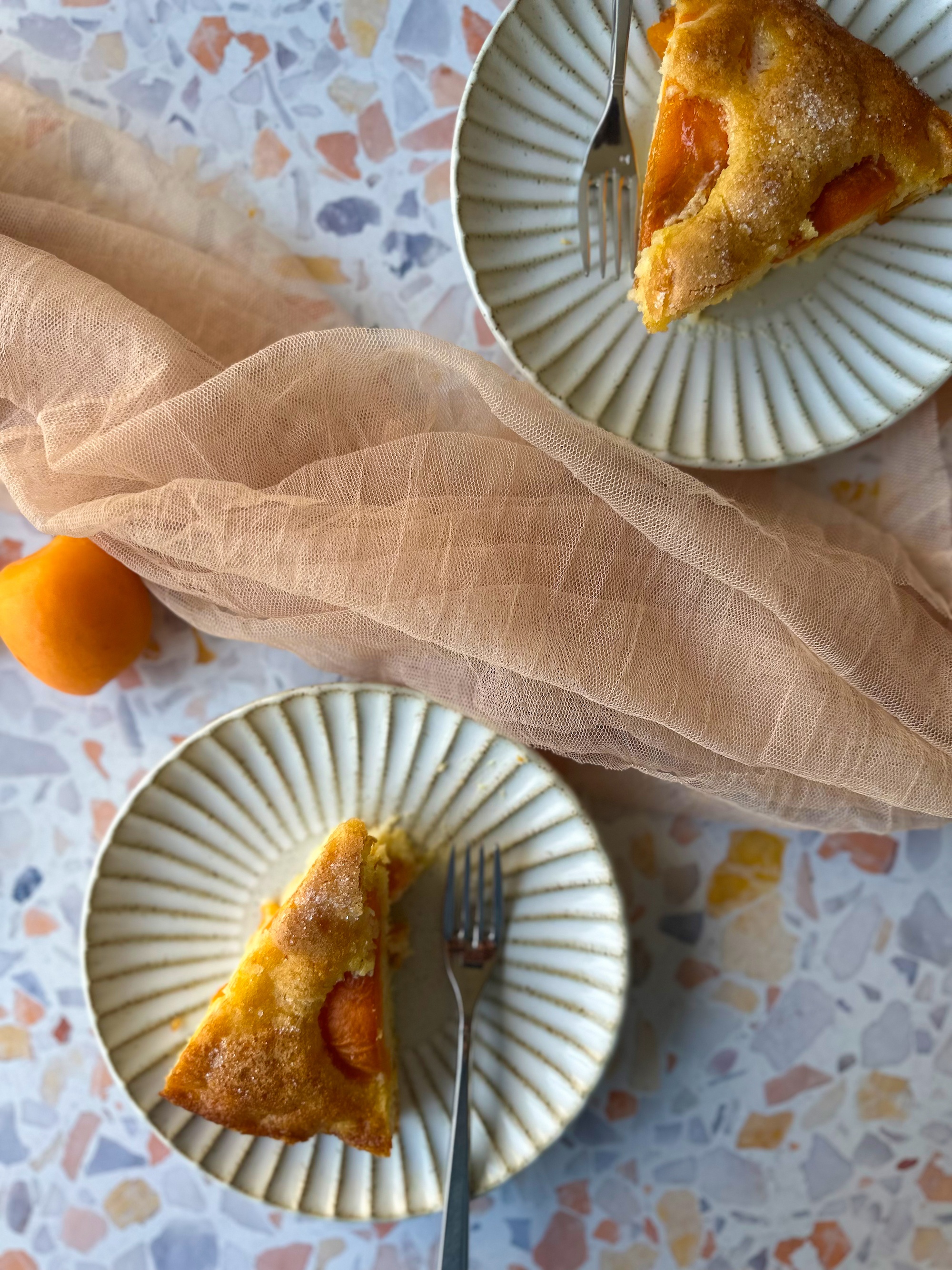 Plates with apricot cake and peach color towel