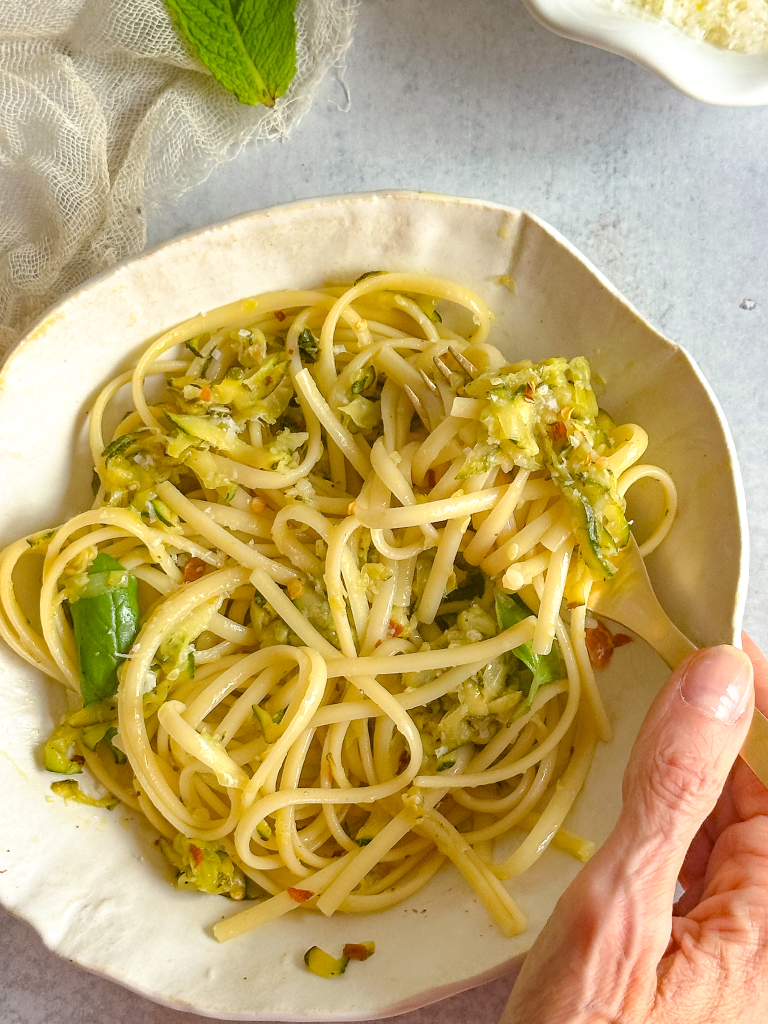 Zucchini pasta hold by a hand