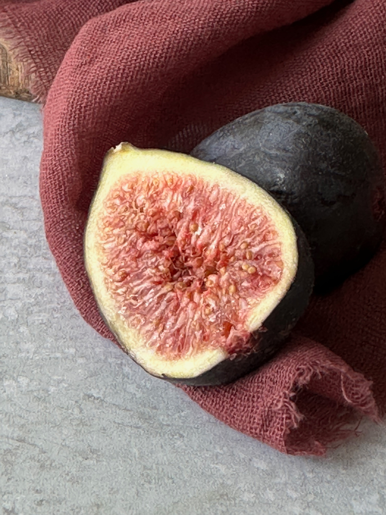Fig cut in half on a burgundy napkin