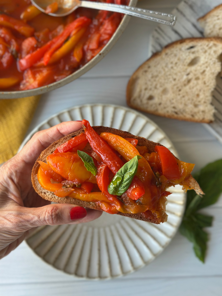 Bread with peperonata on top in hand