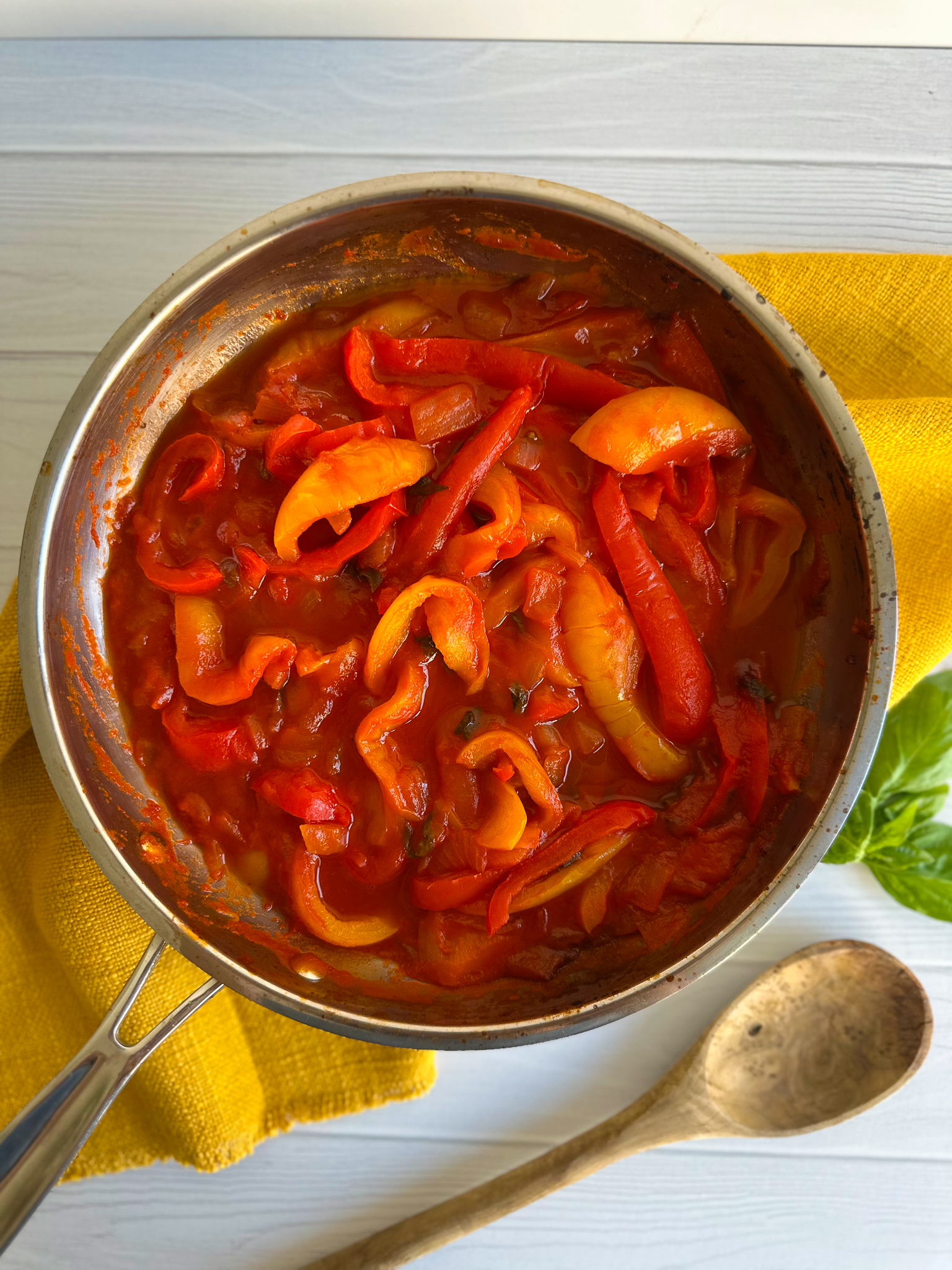 Peperonata in a pot over a yellow kitchen table