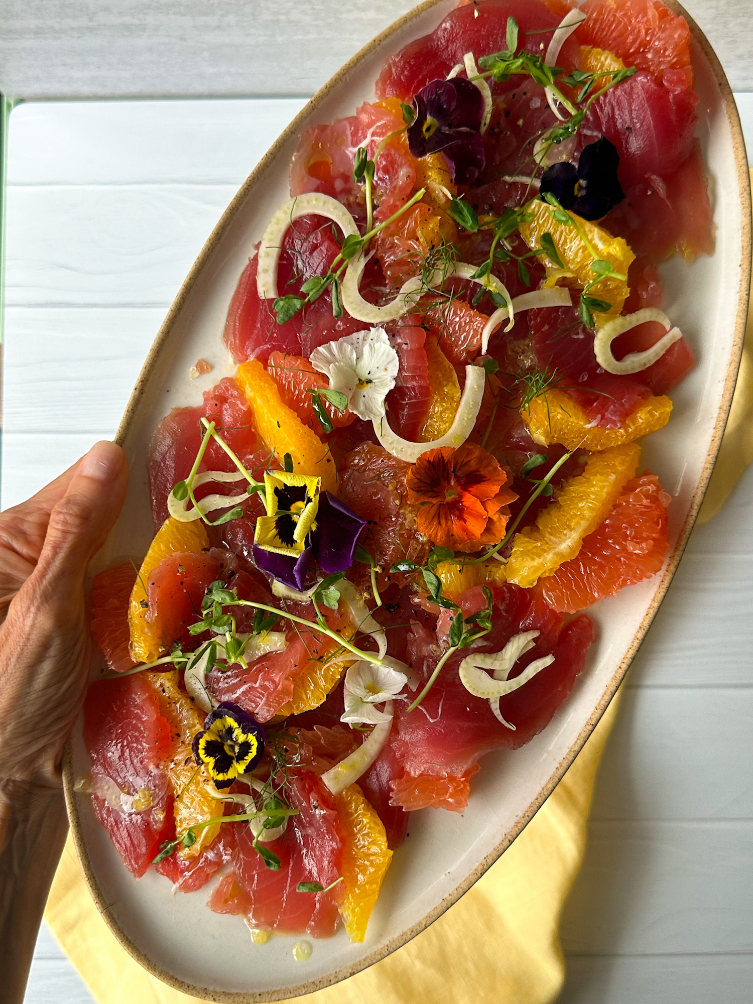 Oval plate of Tuna Crudo Recipe in hand