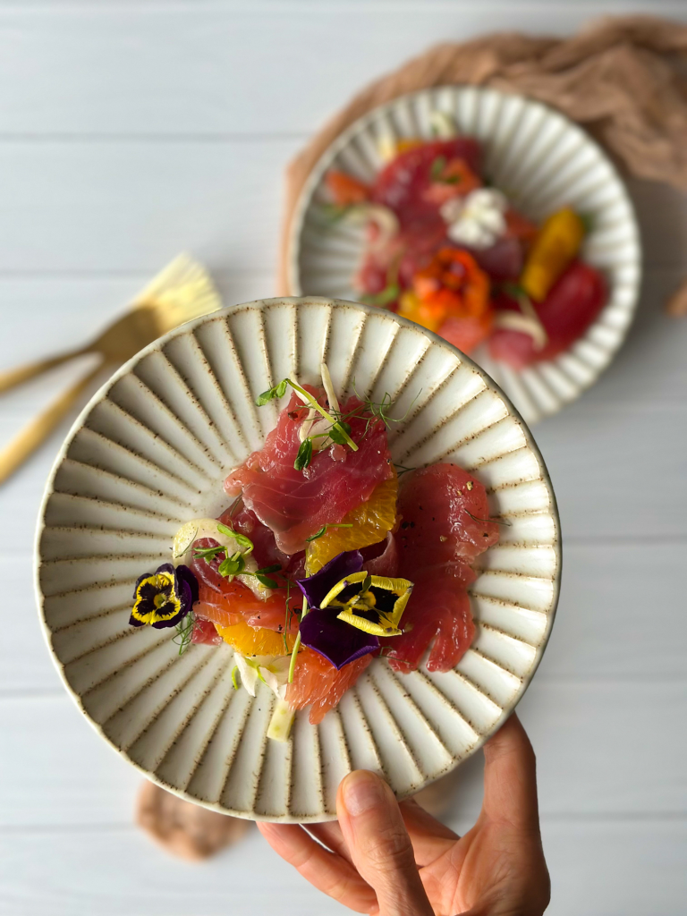Plate of raw Tuna Crudo in hand
