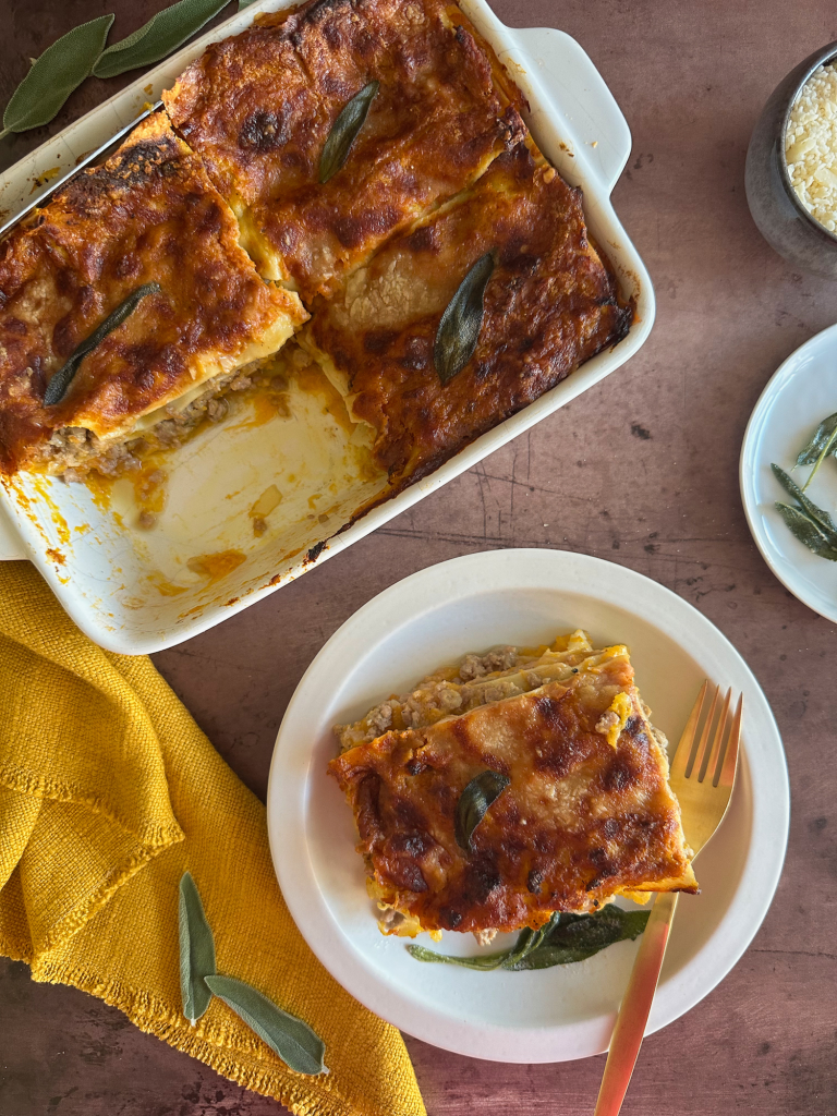 baked lasagna dish with one slice in a plate