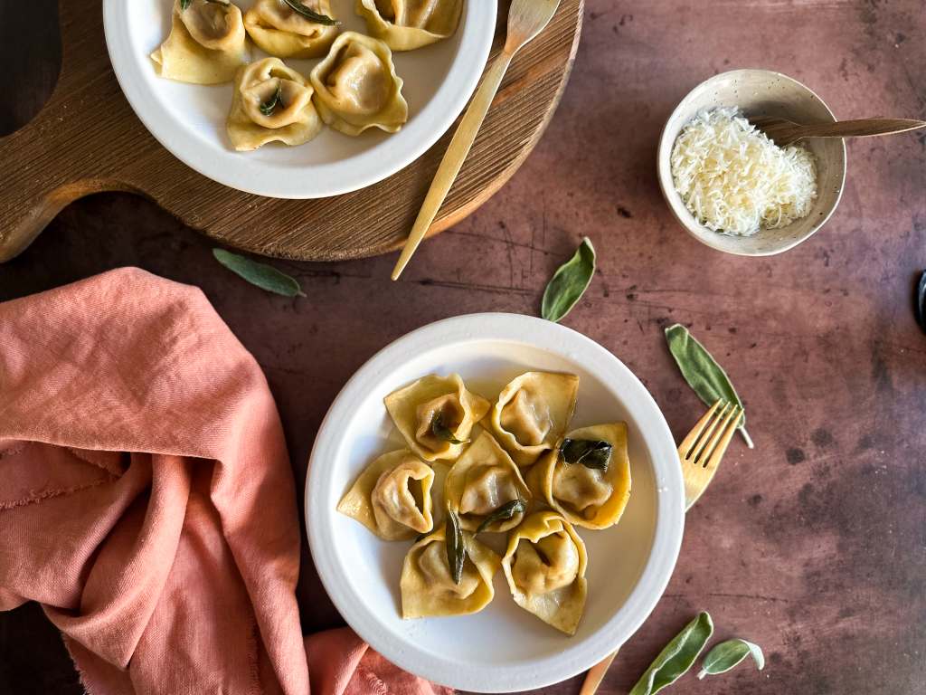 Plates of pumpkin tortelli on a brown table