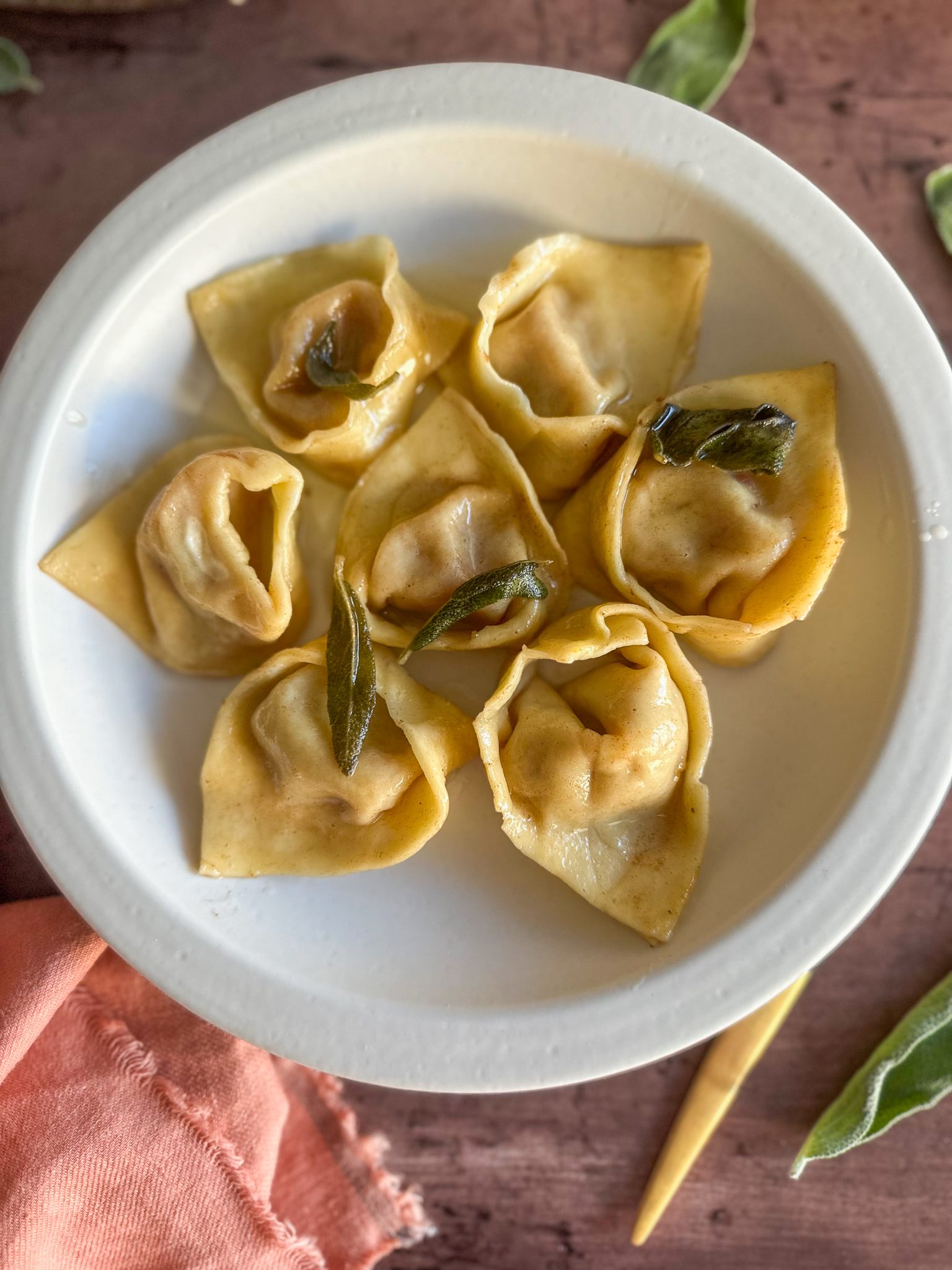 Finished dish Tortelli di Zucca served with sage butter and Parmesan